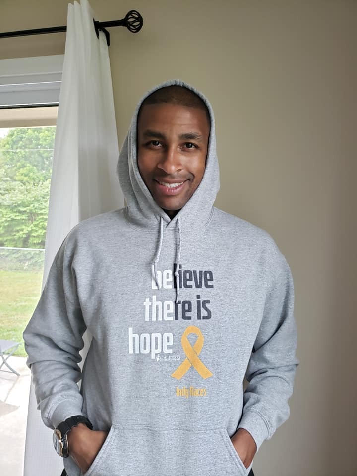 A man wearing a grey 2020 ACCO Cancer Awareness Month hoodie.
