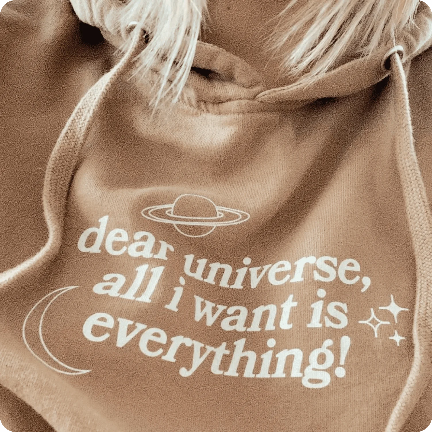 Hoodie featuring minimalist affirmation text paired with simple celestial line icons.