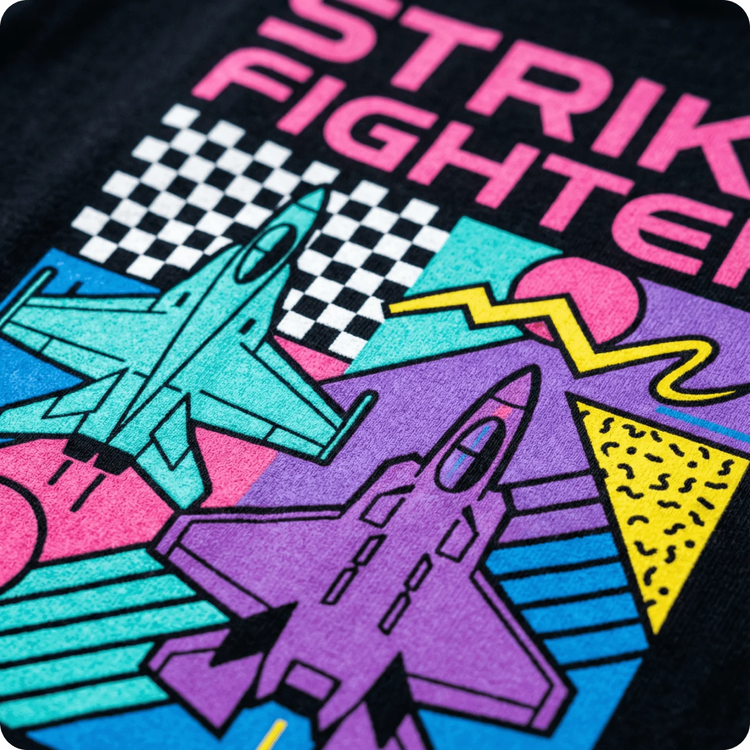 T-shirt featuring retro neon fighter jet illustration inspired by 1980s arcade aesthetics.
